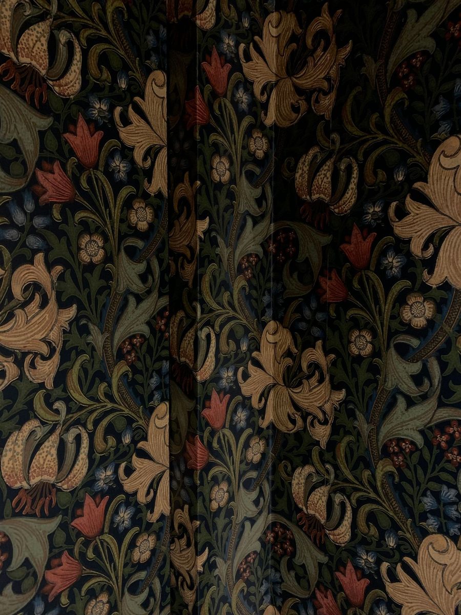 Close-up of intricate Victorian floral wallpaper with dense foliage and flowers